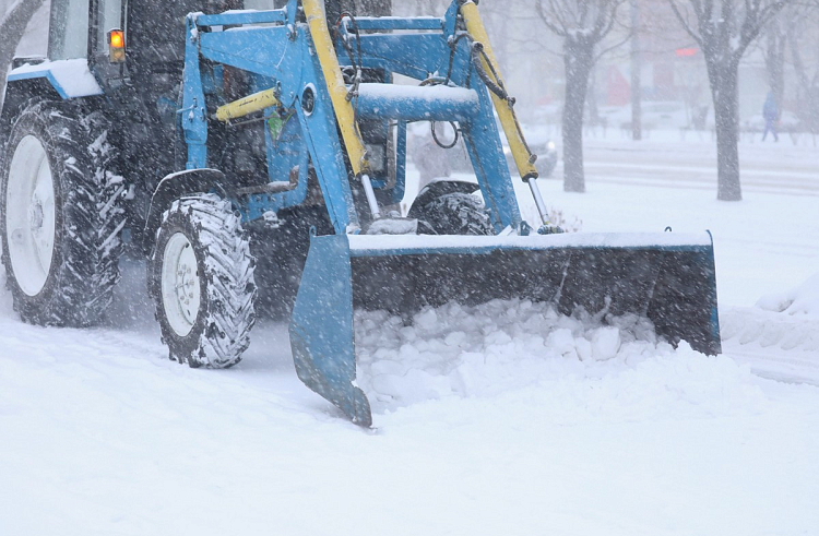 Почти 330 единиц спецтехники работают в снегопад на дорогах Приморья